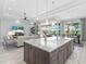 Bright, open-concept kitchen featuring a large island with marble countertops and modern pendant lighting at 16407 Daysailor Trl, Lakewood Ranch, FL 34202