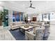 Open-concept living area with stylish furnishings, flowing into the dining and kitchen spaces, with pool views beyond at 16407 Daysailor Trl, Lakewood Ranch, FL 34202