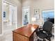Bright home office with a wooden desk, artwork, and views into other areas of the house at 16407 Daysailor Trl, Lakewood Ranch, FL 34202