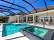 Large screened-in pool and spa with a brick surround and covered patio at 16407 Daysailor Trl, Lakewood Ranch, FL 34202
