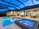 Stunning in-ground pool and hot tub in a screened enclosure, surrounded by a spacious patio and lush landscaping at 16407 Daysailor Trl, Lakewood Ranch, FL 34202