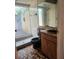 Bathroom with tiled walk-in shower, brown tile floors and vanity with sink at 1862 Orangewood Ln, Sarasota, FL 34232