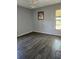 Bedroom with dark laminate floors, neutral wall colors, and a large window at 1862 Orangewood Ln, Sarasota, FL 34232