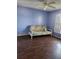 Bedroom with wood laminate floors, blue walls, a ceiling fan, and a day bed at 1862 Orangewood Ln, Sarasota, FL 34232