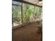 Enclosed patio featuring neutral flooring, wicker furniture, and a view of the lush backyard at 1862 Orangewood Ln, Sarasota, FL 34232