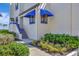 Townhouse exterior with blue awnings, beautifully manicured landscaping, and tiled stairs leading to the entrance at 2010 Harbourside Dr # 2004, Longboat Key, FL 34228