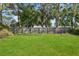 The grassy backyard is bordered by a wooden fence and mature trees at 2039 Kai Dr, Sarasota, FL 34231