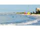 Ocean waves approach the shore on a beach with lifeguard stands and people enjoying a beautiful sunny day at 2039 Kai Dr, Sarasota, FL 34231