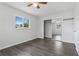 Well-lit bedroom with wood-look flooring, a mirrored closet, and a ceiling fan for added comfort at 2039 Kai Dr, Sarasota, FL 34231