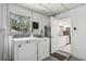 Practical laundry room with washer, dryer, window, and an open doorway to a bright kitchen at 2039 Kai Dr, Sarasota, FL 34231