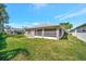 Back exterior of home with screen enclosed lanai and lush, green lawn at 2407 Waterford Ct, Palmetto, FL 34221