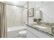 Well-lit bathroom featuring tiled walls, a shower-tub combo, and a granite vanity top at 25258 Estrada Cir, Punta Gorda, FL 33955