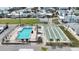 Aerial view featuring a shuffleboard court and a pool surrounded by cozy homes in a vibrant neighborhood at 2601 Gulf N Dr # 214, Bradenton Beach, FL 34217