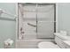 Bathroom featuring tub and shower combination with sliding glass door, grab bar, and white tiled walls at 2625 Terra Ceia Bay Blvd # 506, Palmetto, FL 34221