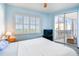 Bright bedroom with sliding glass doors to balcony, ceiling fan, shutters, and light blue walls at 2625 Terra Ceia Bay Blvd # 506, Palmetto, FL 34221