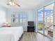 Bright bedroom with sliding glass doors to balcony, ceiling fan, shutters, and light blue walls at 2625 Terra Ceia Bay Blvd # 506, Palmetto, FL 34221