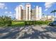 Stunning exterior view of a condo building with a manicured lawn, palm trees, and a car at 2625 Terra Ceia Bay Blvd # 506, Palmetto, FL 34221