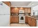 Efficient kitchen with wood cabinets, white appliances, and granite countertops at 2625 Terra Ceia Bay Blvd # 506, Palmetto, FL 34221