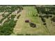 A serene aerial view of a property featuring a pond with a unique double pool shape at 28120 63Rd E Ave, Myakka City, FL 34251
