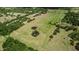 A serene aerial view of a property featuring a pond with a unique double pool shape at 28120 63Rd E Ave, Myakka City, FL 34251