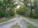 Long, gravel driveway leading to a wooded property, offering privacy and seclusion at 28120 63Rd E Ave, Myakka City, FL 34251