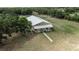 Aerial view of a charming barndominium with a metal roof and well-maintained landscaping at 28120 63Rd E Ave, Myakka City, FL 34251