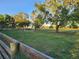 Green field with mature trees, offering privacy and natural beauty, enclosed by wooden fencing at 28120 63Rd E Ave, Myakka City, FL 34251