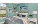 Cozy bedroom featuring a large window, bamboo headboard, and soothing color palette with beach themed artwork at 3169 Alba Cir, Bradenton, FL 34211
