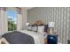 Stylish bedroom with a large window, patterned wallpaper, and elegant decor for a cozy retreat at 3169 Alba Cir, Bradenton, FL 34211