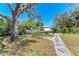The well-manicured backyard features a charming stone path, a mature tree and a delightful swing creating a serene outdoor space at 3304 7Th Street W Ct, Palmetto, FL 34221