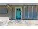 Close-up of a bright turquoise front door adding a touch of charm to the home's exterior at 3304 7Th Street W Ct, Palmetto, FL 34221