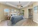 Bedroom with hardwood floors, a ceiling fan, and direct access to the lanai at 428 Grand Preserve Cv, Bradenton, FL 34212
