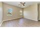 Bright bedroom with two windows, ceiling fan, and wood-look flooring at 428 Grand Preserve Cv, Bradenton, FL 34212