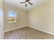 Bright bedroom featuring a ceiling fan, plank floors, and a window with a view of the outdoors at 428 Grand Preserve Cv, Bradenton, FL 34212