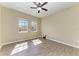 Bright bedroom with two windows, ceiling fan, and wood-look flooring at 428 Grand Preserve Cv, Bradenton, FL 34212