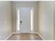Real estate image of a home's entryway, featuring a white door, sidelights, and modern flooring at 428 Grand Preserve Cv, Bradenton, FL 34212