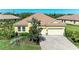 Charming yellow single-story home with a brick driveway, well-maintained landscaping, and a tile roof at 428 Grand Preserve Cv, Bradenton, FL 34212