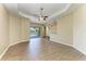 Large living room featuring hardwood floors, neutral paint, and sliding glass doors that lead to the lanai at 428 Grand Preserve Cv, Bradenton, FL 34212