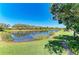 Scenic view of a serene lake surrounded by lush greenery and a clear blue sky at 428 Grand Preserve Cv, Bradenton, FL 34212