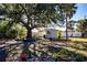Backyard with a storage shed, mature trees, and landscaping at 4360 Flamingo Blvd, Port Charlotte, FL 33948
