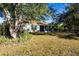 Green backyard featuring mature shade trees and a screened-in porch at 4360 Flamingo Blvd, Port Charlotte, FL 33948