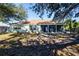 The backyard features a screen porch along the back of the house and a lawn partially shaded by mature trees at 4360 Flamingo Blvd, Port Charlotte, FL 33948
