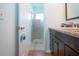 Bathroom with wood-look floor, dark vanity, granite counter, and tiled shower room with glass door at 4360 Flamingo Blvd, Port Charlotte, FL 33948