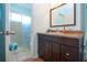 Bathroom with dark vanity, granite counter, and tiled shower with glass doors at 4360 Flamingo Blvd, Port Charlotte, FL 33948
