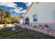 A charming home exterior with an arched entryway, garden lights, potted plants, and fresh landscaping at 4360 Flamingo Blvd, Port Charlotte, FL 33948