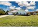 Charming single story home featuring a lush front lawn, attached garage, and arched entryway at 4360 Flamingo Blvd, Port Charlotte, FL 33948