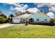 Charming single story home featuring a lush front lawn, attached garage, and arched entryway at 4360 Flamingo Blvd, Port Charlotte, FL 33948