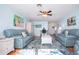 Bright living room with blue couches, accent rug, ceiling fan, and light blue walls at 4360 Flamingo Blvd, Port Charlotte, FL 33948