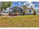 Seating and brick patio are part of the screened-in lanai area in this lush backyard at 4406 17Th W St, Palmetto, FL 34221
