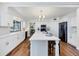 Modern white kitchen featuring stainless steel appliances, a large island with seating, and hardwood flooring at 4406 17Th W St, Palmetto, FL 34221